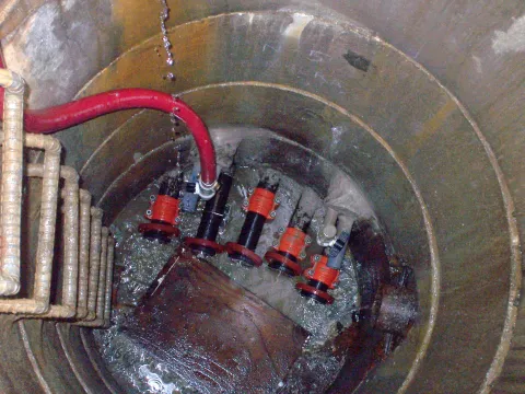 Adak - Inserted 2" fill pipes inside of 6" host pipes in 4' sections glued together to extend 100' under 4 fuel tanks. Pipes were bulkheaded and annular space filled.