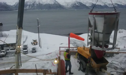 Seward- lifting shotcrete a bucket at a time to feed the pump.